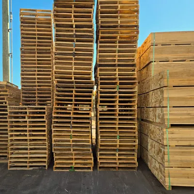 Tall stacks of standard wood pallets